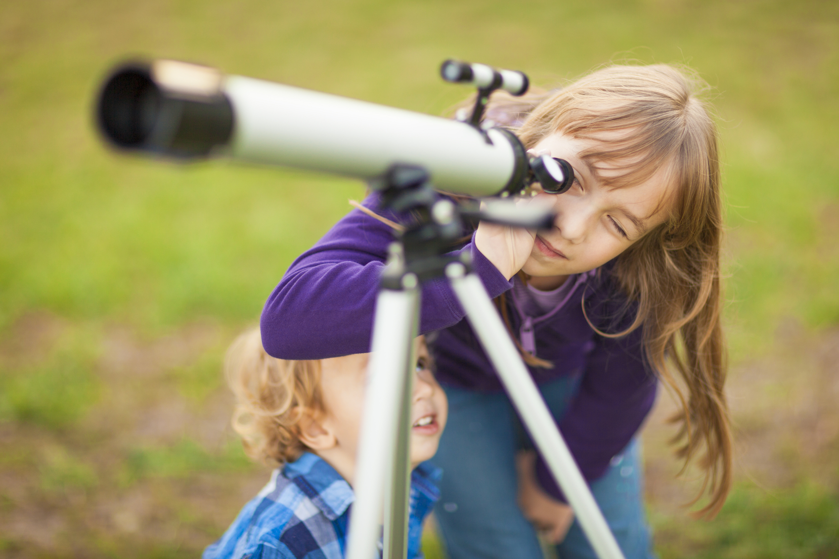 Little girl looking through telescope outdoors Bibouille